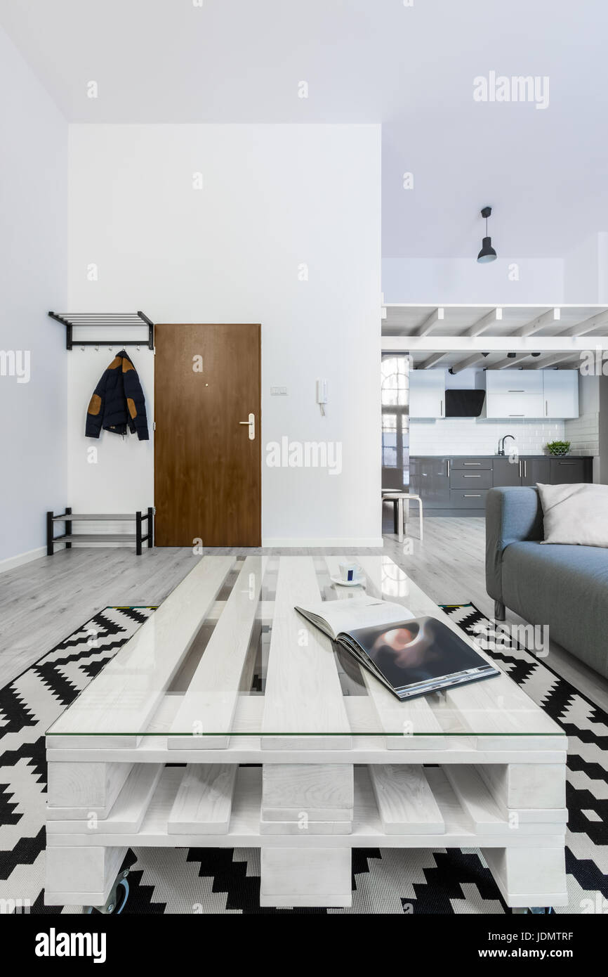 White salon avec table et palettes bricolage tapis motif Banque D'Images