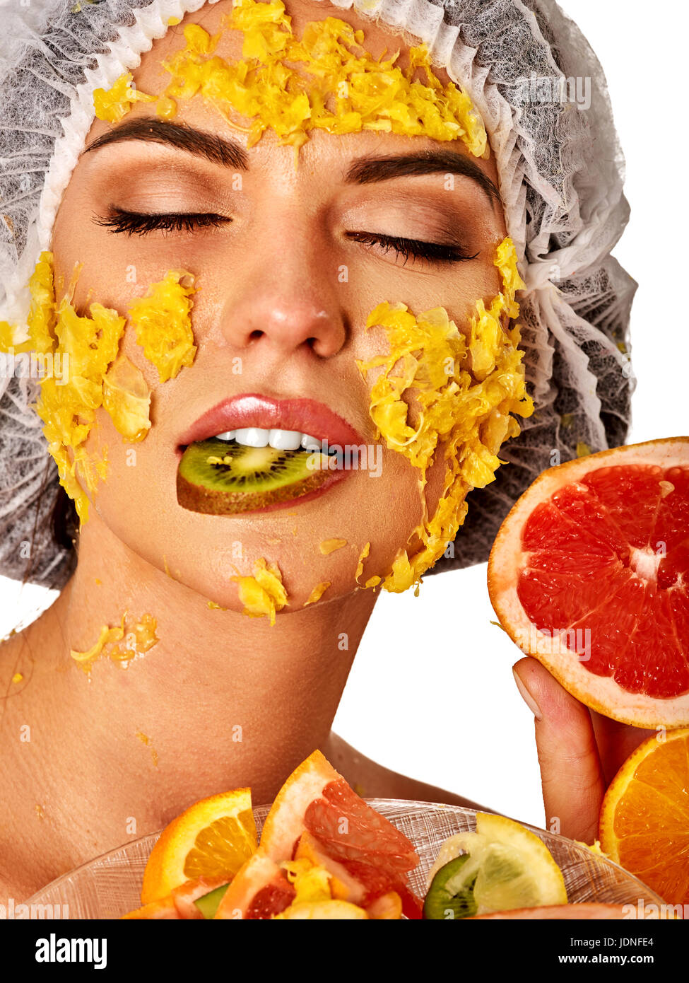 Fruits du visage masque pour femme. Fille avec la pulpe de mangue sont confrontés. Banque D'Images