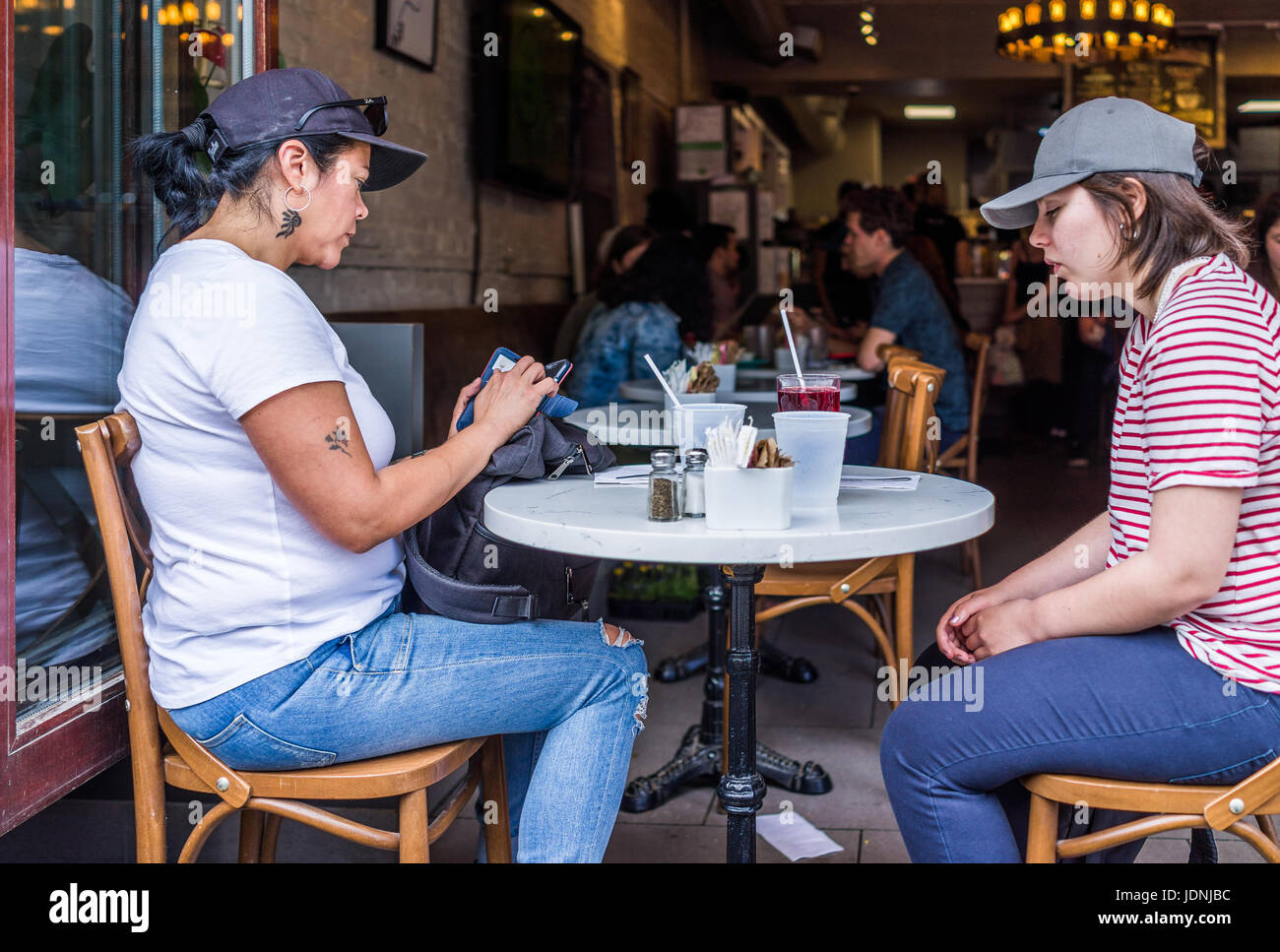 Montréal, Canada - le 27 mai 2017 : Les femmes des gens assis au restaurant à table avec fenêtres ouvertes au quartier le plateau en ville dans la région du Québec Banque D'Images