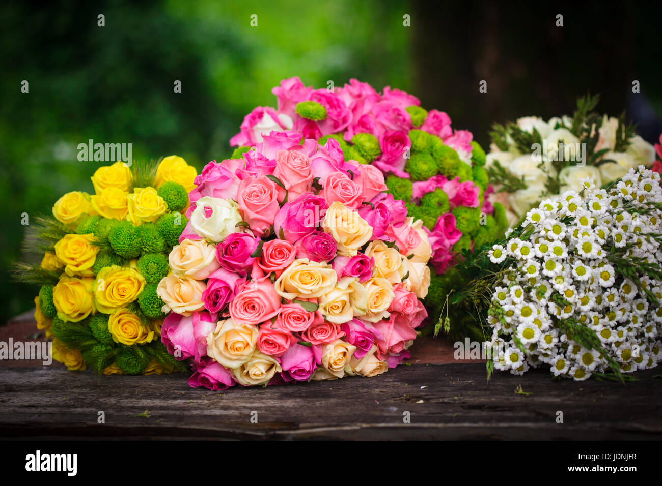 Deux bouquets de roses rose et jaune sur une table du fleuriste en bois Banque D'Images