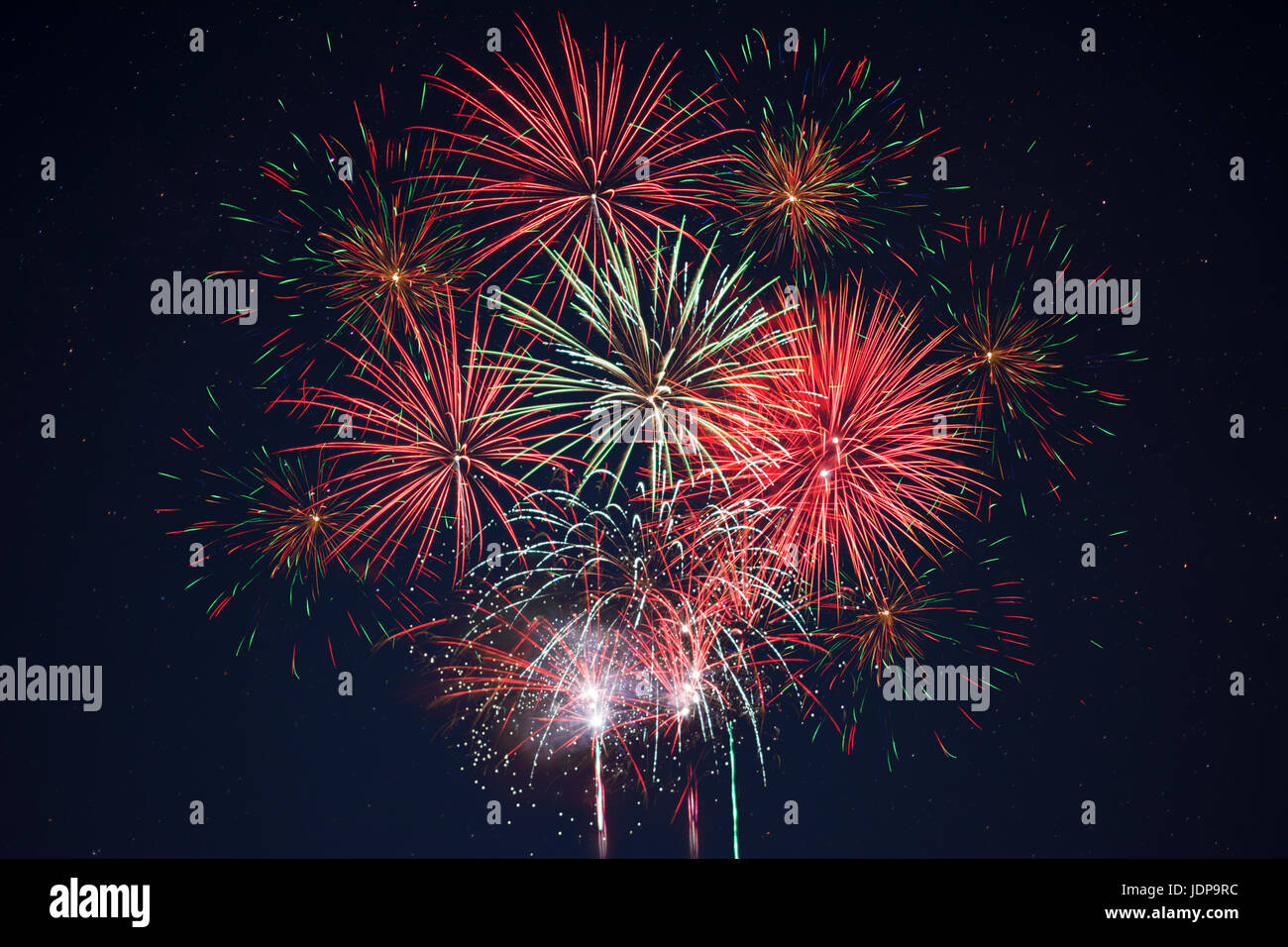 Mousseux rouge vert jaune célébration d'artifice au-dessus ciel étoilé. Le jour de l'indépendance, le 4 juillet, jour de l'an saluer l'arrière-plan. Banque D'Images