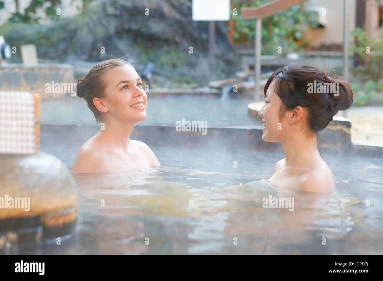 Caucasian woman avec ami japonais echelle à traditionnel Hot spring, Tokyo, Japon Banque D'Images