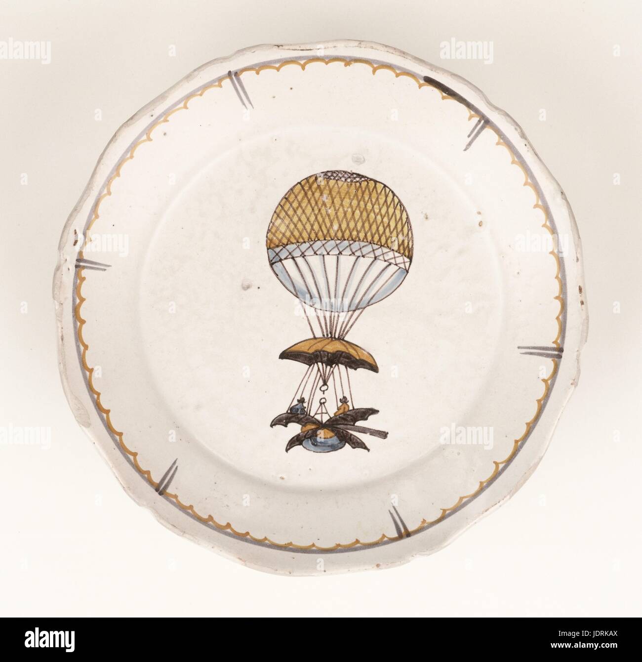 Faïence polychrome a tiré sur un feu vif avec bordure incurvée, Nevers M. Blanchard's flying vessel diameter 23 cm Muller-Quênot Collection après son annonce en juin 1783 pour rendre sa machine fly, Jean-Pierre Blanchard a pris exemple sur Mr D's book... . Quel que soit le cas, il a été le premier pilote à avoir élaboré une machine à diriger le vol d'un ballon. À partir de la fin de 1783, Jean-Pierre Blanchard construit un ballon de soie vernissée, qui permettrait d'adapter les différentes parties de sa machine volante. Ce fut abandonné quelques mois plus tard. Il a ajouté un ballon à la gouverne et deux ensembles de pagaies. Banque D'Images