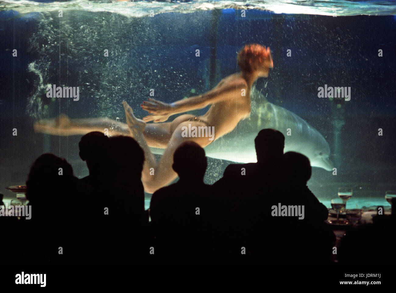 Swimmer avec dauphin en réservoir dans Moulin Rouge, Clichy, Paris, France Banque D'Images