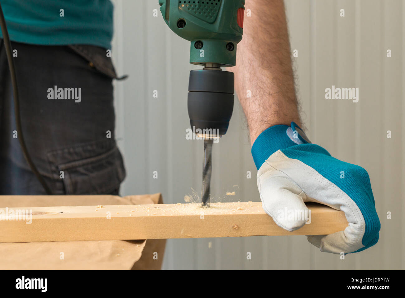 Carpenter handyman en utilisant la perceuse électrique pour faire des trous sur la planche sur la table de l'atelier de menuiserie Banque D'Images