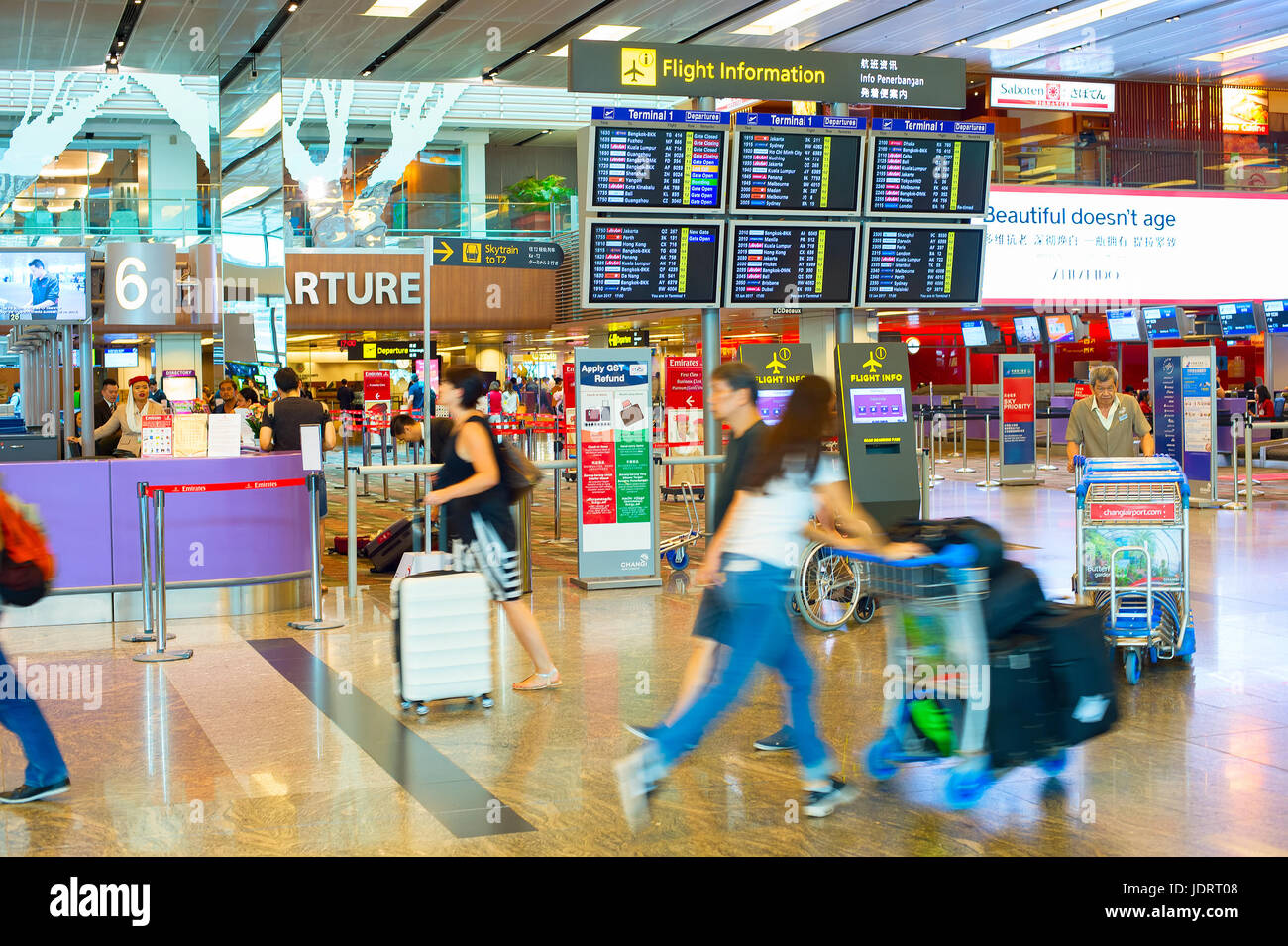 Singapour - Le 13 janvier 2017 : Les passagers à la hâte près de la commission d'information, à l'aéroport de Changi. L'aéroport de Changi est au service de plus de 100 compagnies aériennes s'élève Banque D'Images