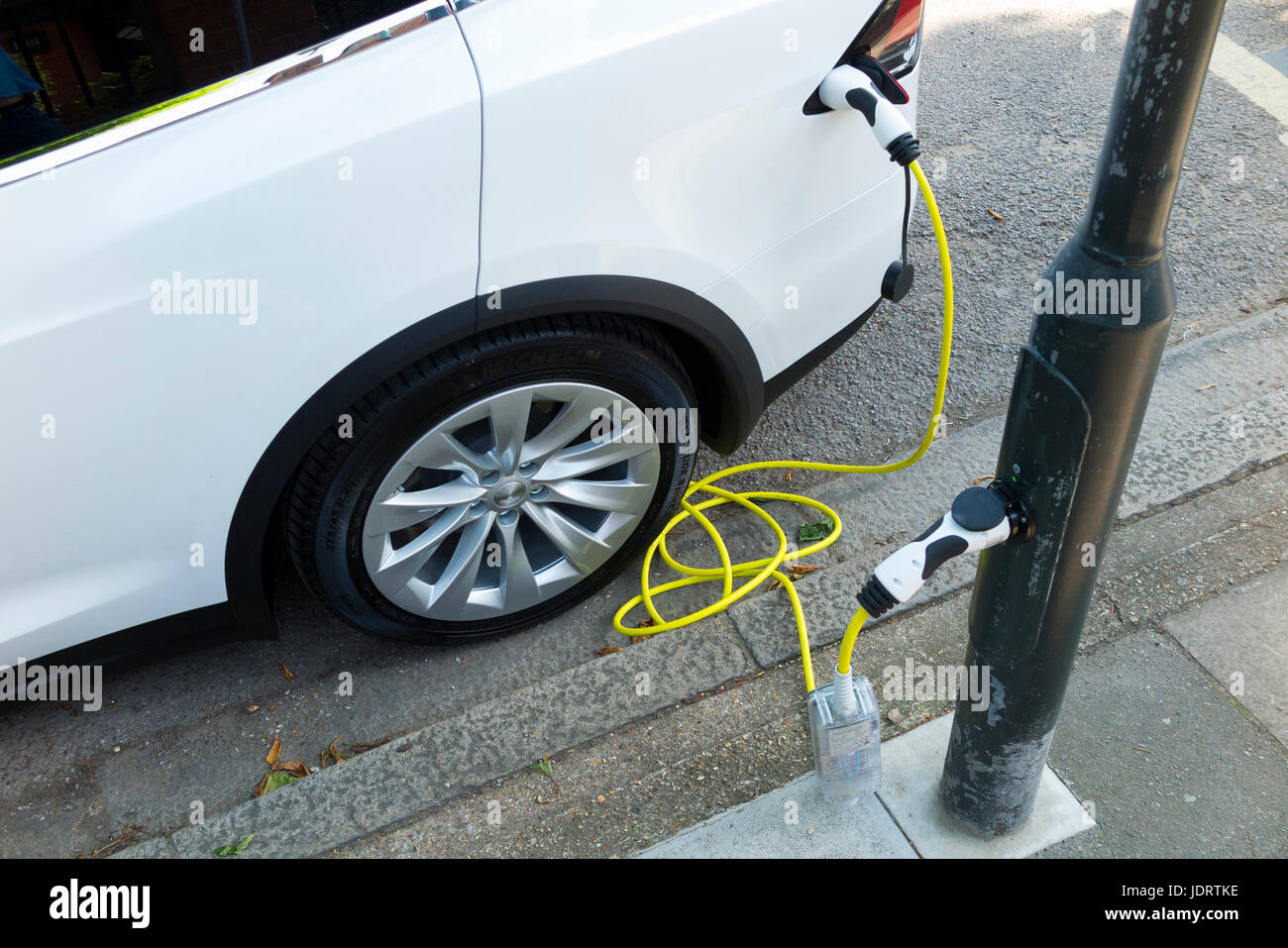Conversion d'un chargeur de voiture électrique par Ubitricity : câble intelligent sur une lampe de rue qui peut maintenant être utilisé pour charger un véhicule électrique à partir du montant de lampe (dans ce cas, un Tesla.)Twickenham Royaume-Uni Banque D'Images