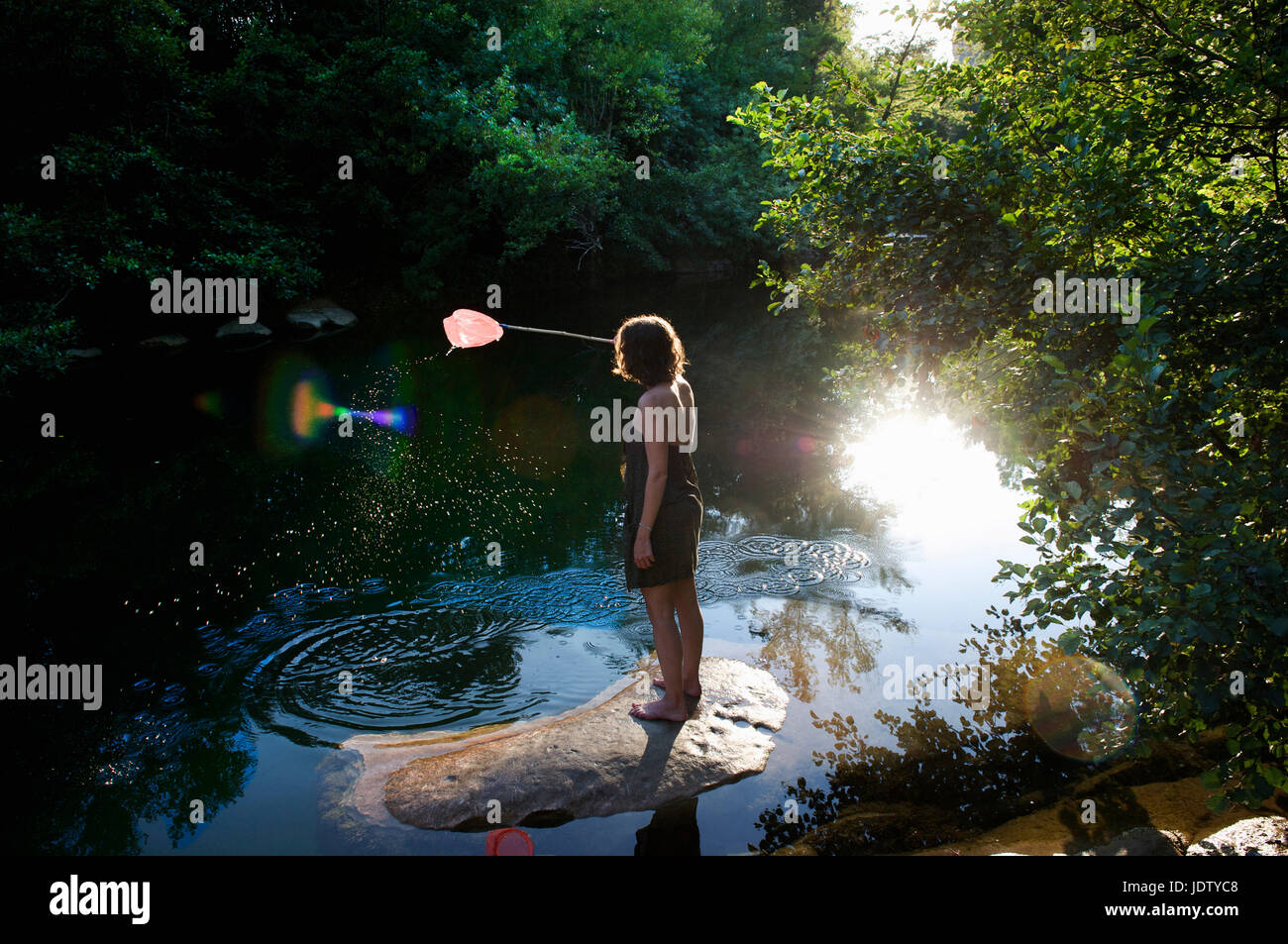 Femme prendre du poisson avec net in river Banque D'Images