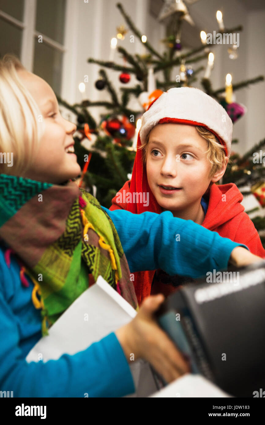 Les enfants d'ouvrir les cadeaux de Noël Banque D'Images