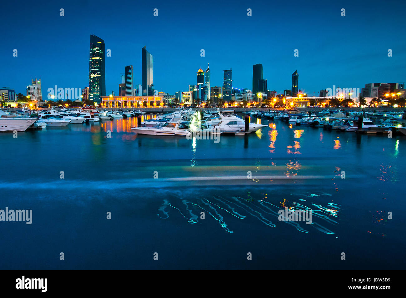 Boats docked in urban harbor at night Banque D'Images