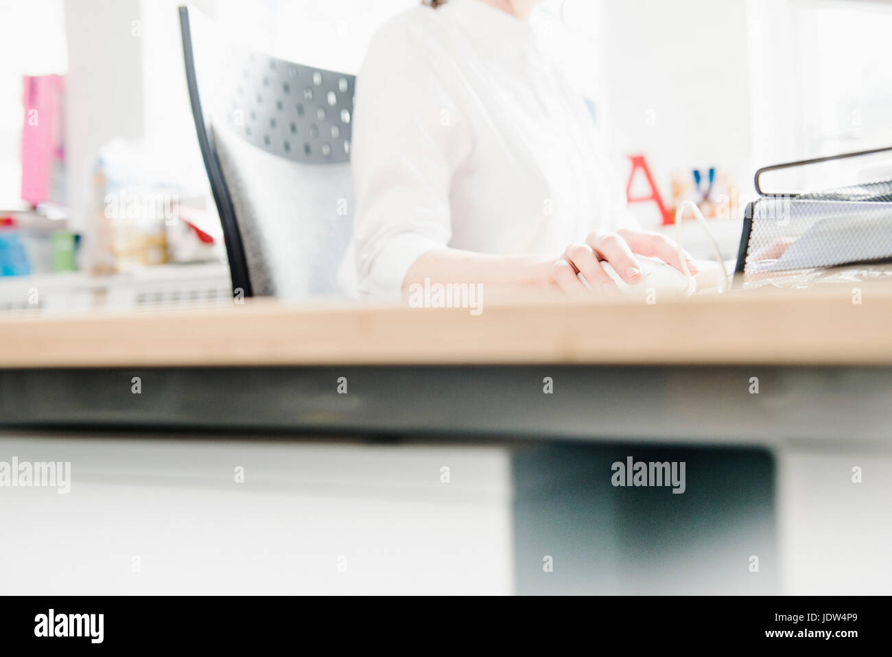 Female office worker using computer mouse Banque D'Images