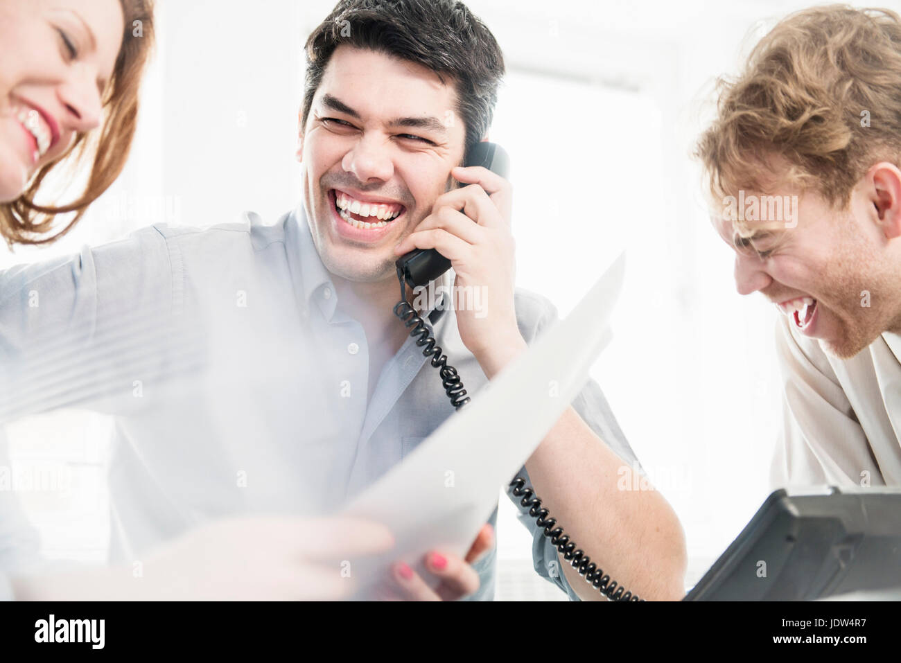 Man on telephone rire avec ses collègues Banque D'Images