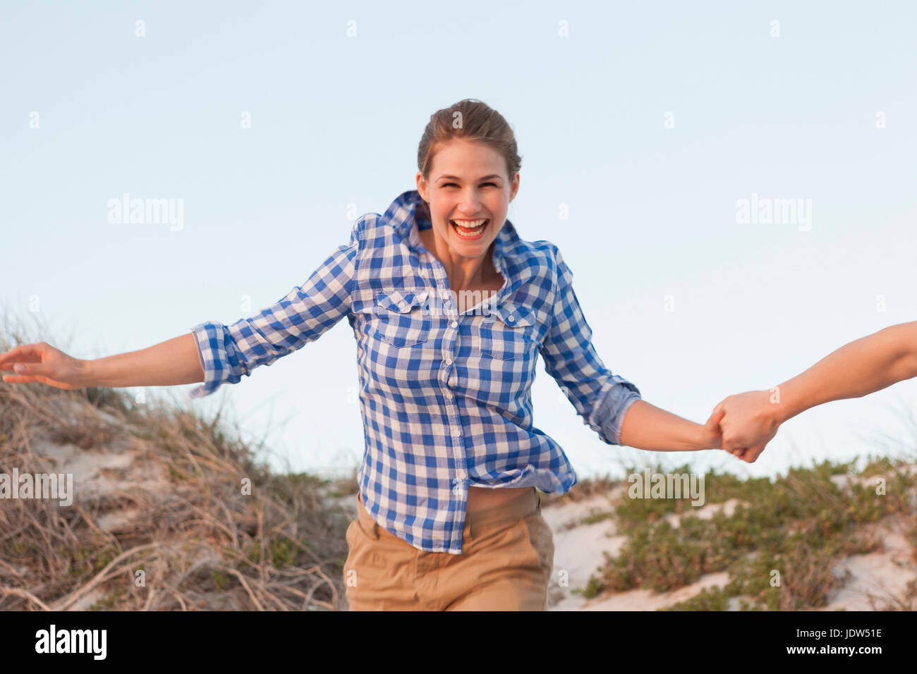 Woman running on beach holding hands with man Banque D'Images