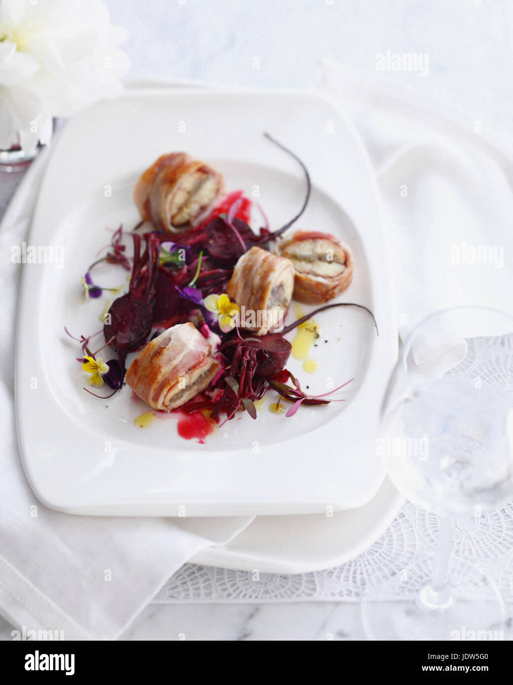 Assiette de l'anguille fumée enrobé de bacon avec salade de betterave Banque D'Images