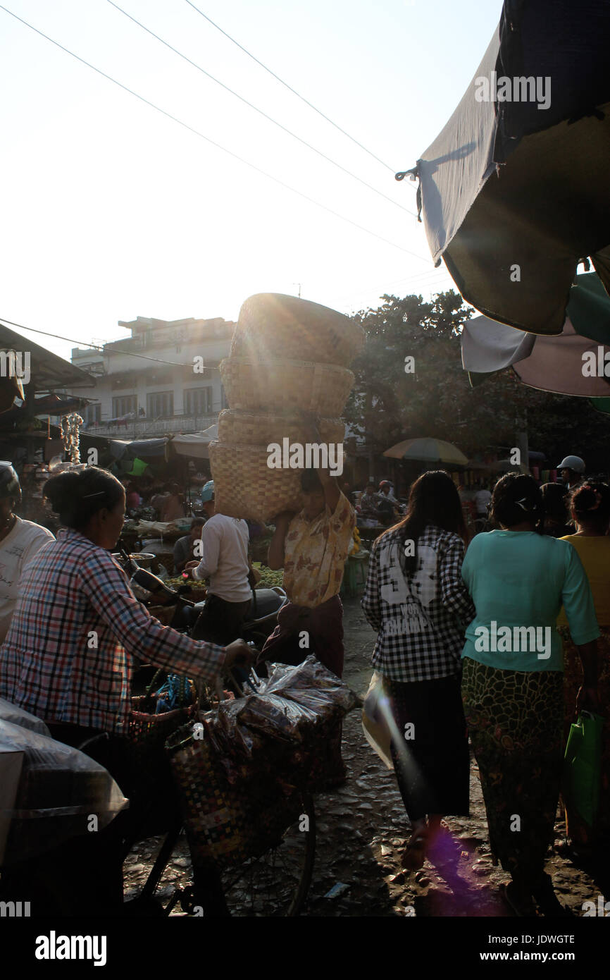 Marché Zegyo/Mandalay Myanmar - 22 janvier 2016 : un homme porte un aliment de grands paniers sur ses épaules, tandis que le soleil est sur le point de mettre au-dessus de l'Homme Banque D'Images