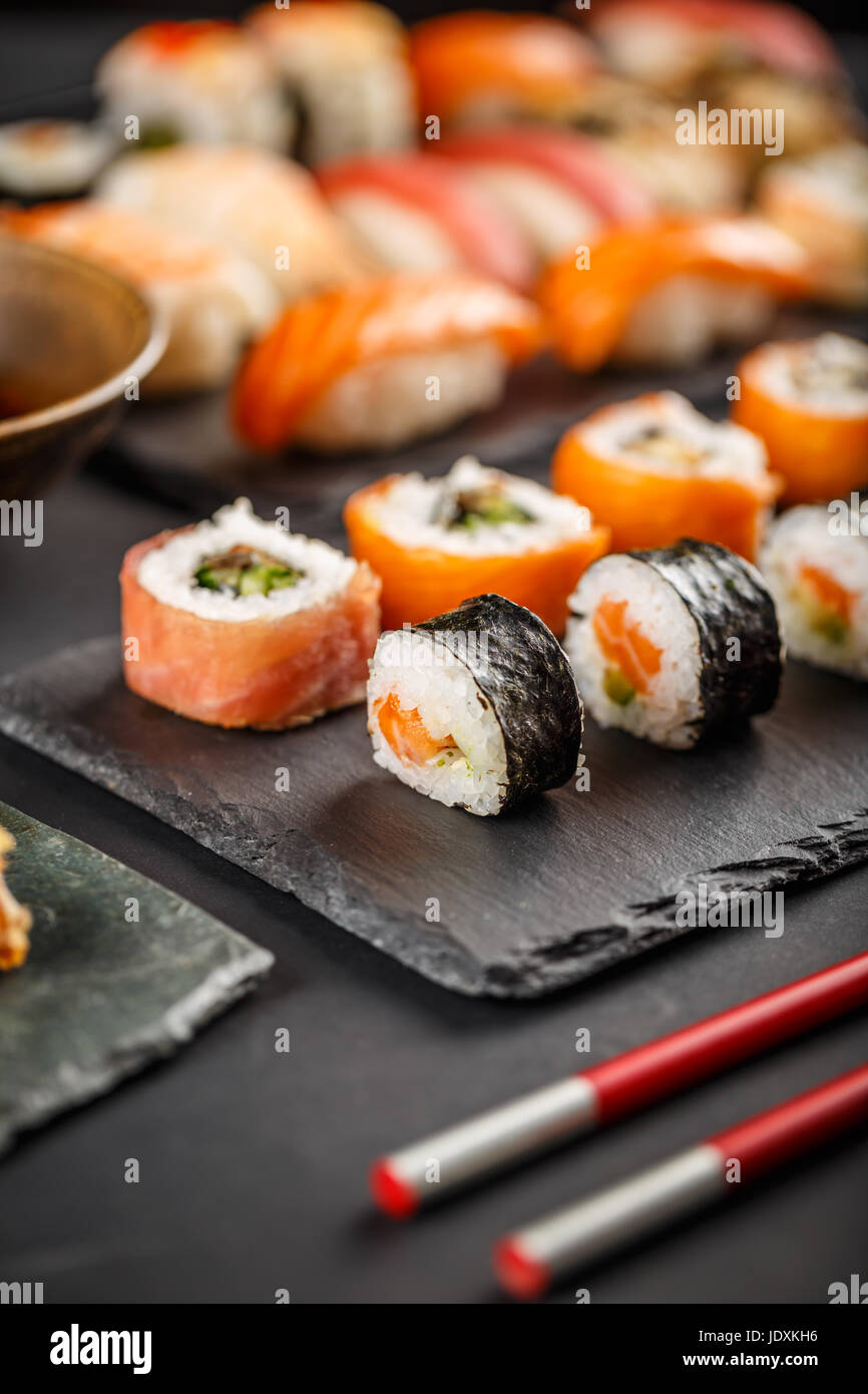 Plaque de sushi avec des baguettes sur fond noir Banque D'Images