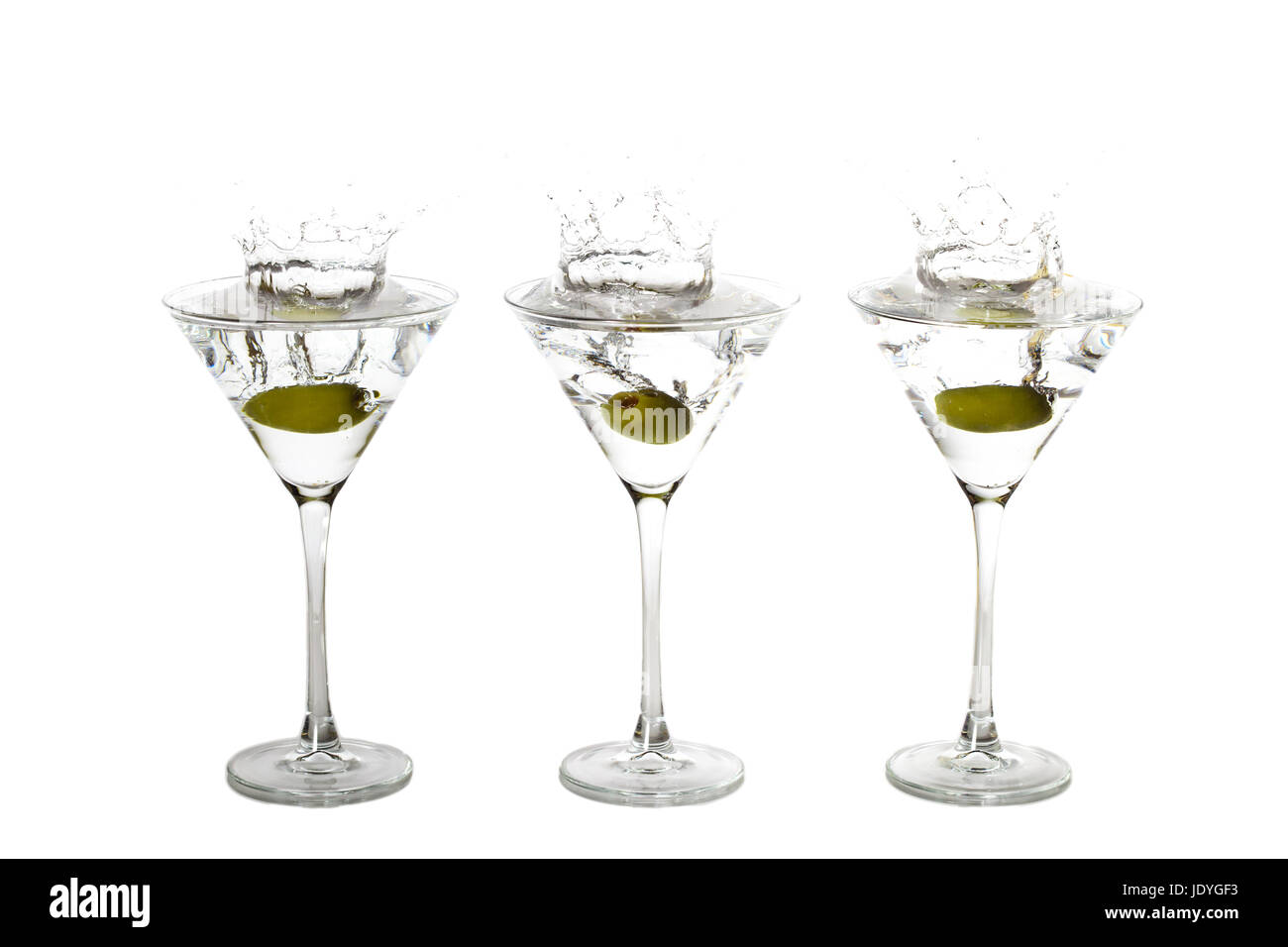 Olives Les projections dans trois verres à martini en même temps. Banque D'Images