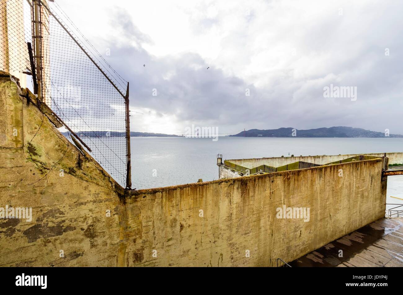 La cour de récréation sur l'île pénitencier d'Alcatraz, maintenant un musée, à San Francisco, Californie, USA. Une vue de la cour d'exercice, la clôture de la prison, le cellhouse, l'île au trésor et le pont de la baie. Banque D'Images