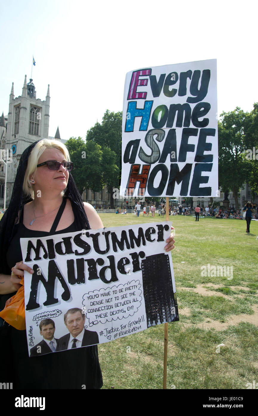 Londres, Royaume-Uni. 21 Juin, 2017. Jour de protestation contre la rage après l'incendie à la maison Grenfell, à l'ouest de Londres. Une femme tient deux plaques - L'un dit 'Chaque maison une maison sûre', l'autre dit "isummer meurtre', faisant référence à l'incendie et programme Crédit : Jenny Matthews/Alamy Live News Banque D'Images