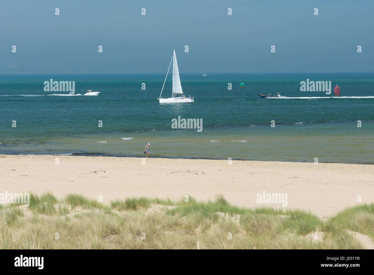 Studland Beach, péninsule de Purbeck, Dorset, UK, 21 juin 2017. Sur ce qui pourrait être le dernier jour de la vague de chaleur actuelle, c'est un autre jour par temps chaud et ensoleillé sur la belle étendue de sable de la côte sud populaire avec les vacanciers et les excursionnistes. Une brise de mer animé les températures à 24 degrés, quelques degrés de moins que le record la température enregistrée à l'intérieur des terres. Une navigation à voile blanche par. Banque D'Images