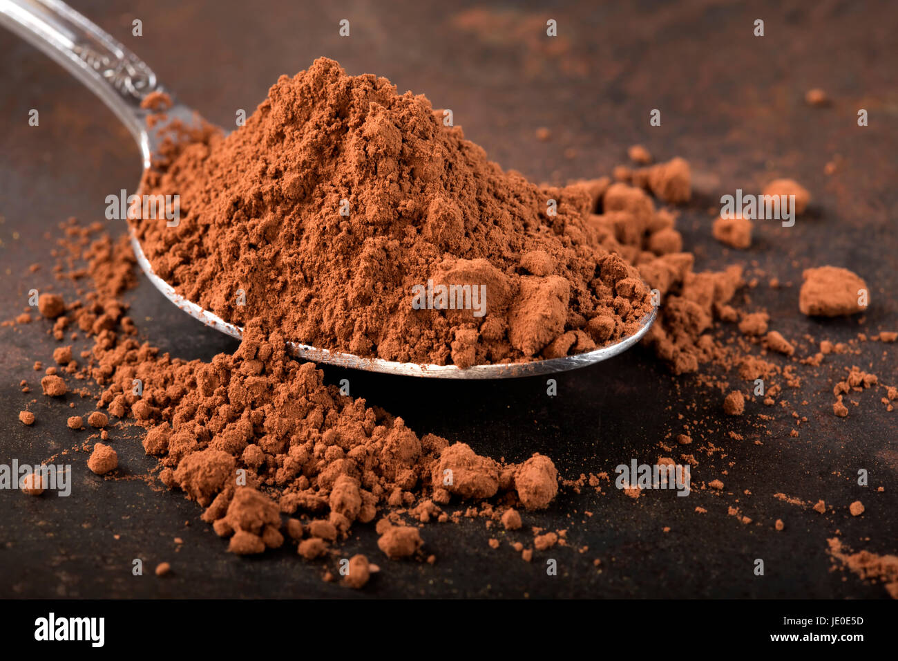 Cuillère remplie de cacao sur fond rouille Banque D'Images