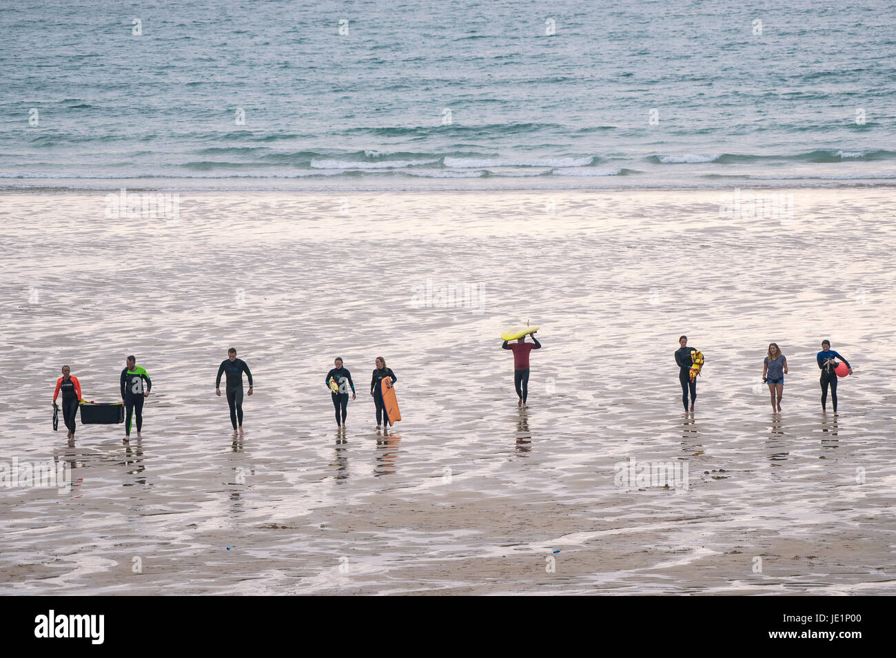 Les gens qui marchent sur la plage de Fistral après un exercice de sauvetage de surf. Banque D'Images