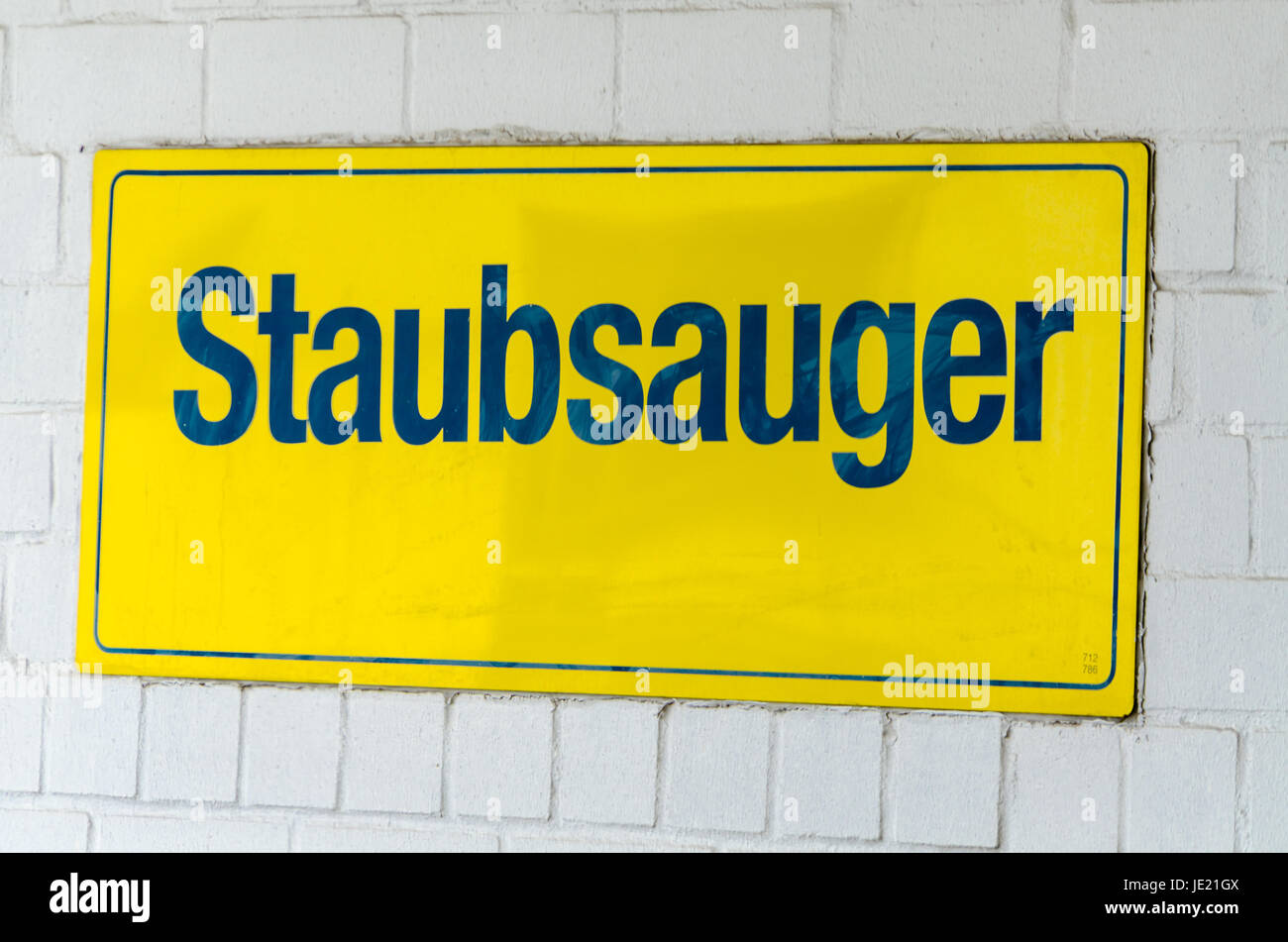 Gelbes Schild mit der Aufschrift Staubsauger auf einer Wand. Banque D'Images