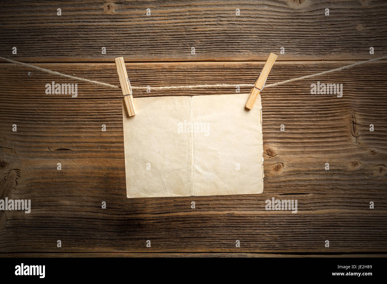 Fixer le papier à corde avec pinces à linge sur fond de bois Photo Stock -  Alamy