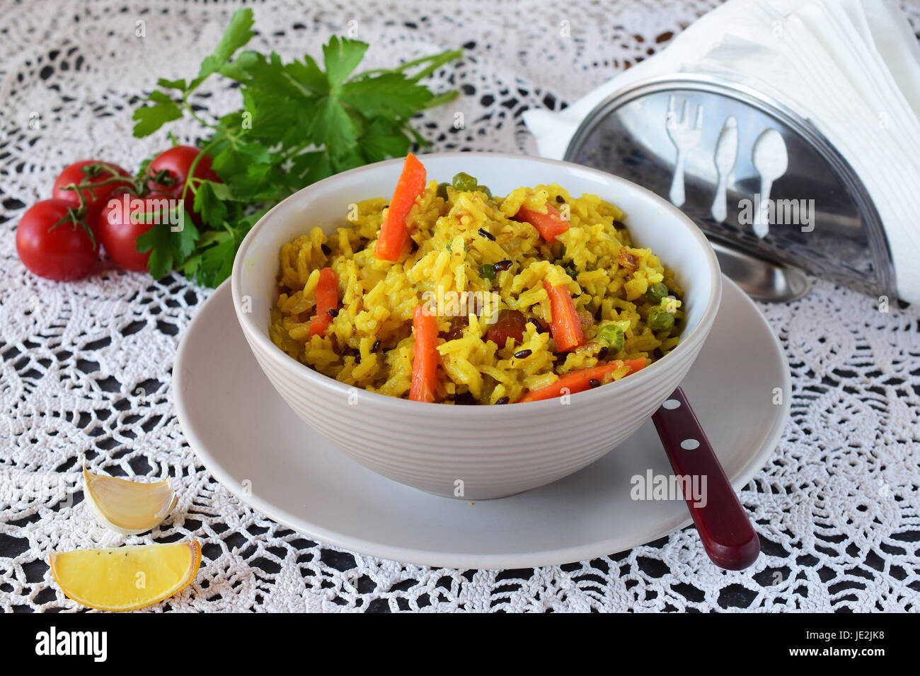 Facile à cuire avec le riz, les carottes, les oignons et les raisins secs dans un bol d'huile d'olive sur un fond blanc. Concept de saine alimentation Banque D'Images