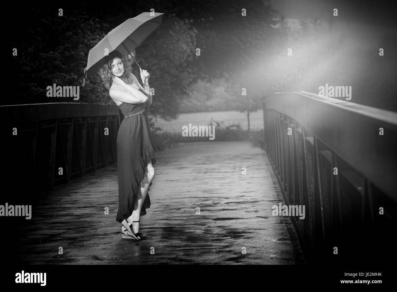 Jeune jolie femme avec parapluie rouge après la pluie dans la nature Banque D'Images