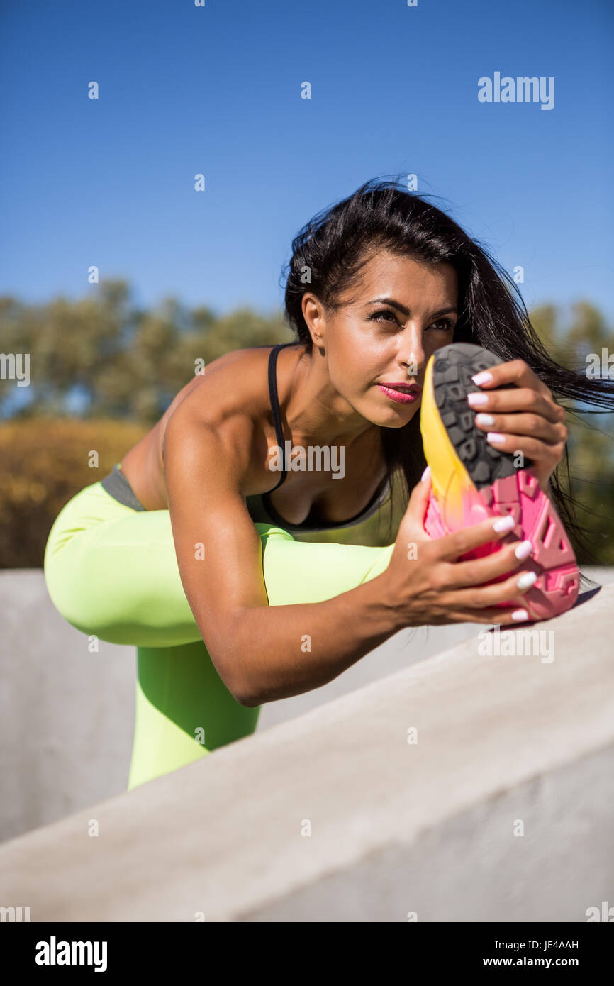 Belle jeune femme avec de longues jambes dans des leggings sexy avec le joli corps musclé de l'athlète les étirements avant le yoga. Formation Crossfit urbain st Banque D'Images