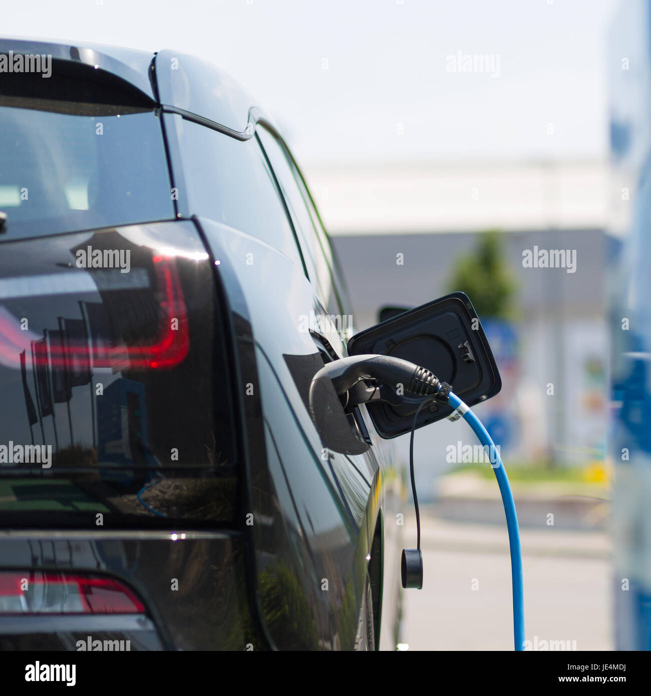 Alimentation pour voiture électrique de la charge. Station de recharge pour voitures électriques. Close up du bloc d'alimentation branché sur une voiture électrique en cours de charge. Banque D'Images