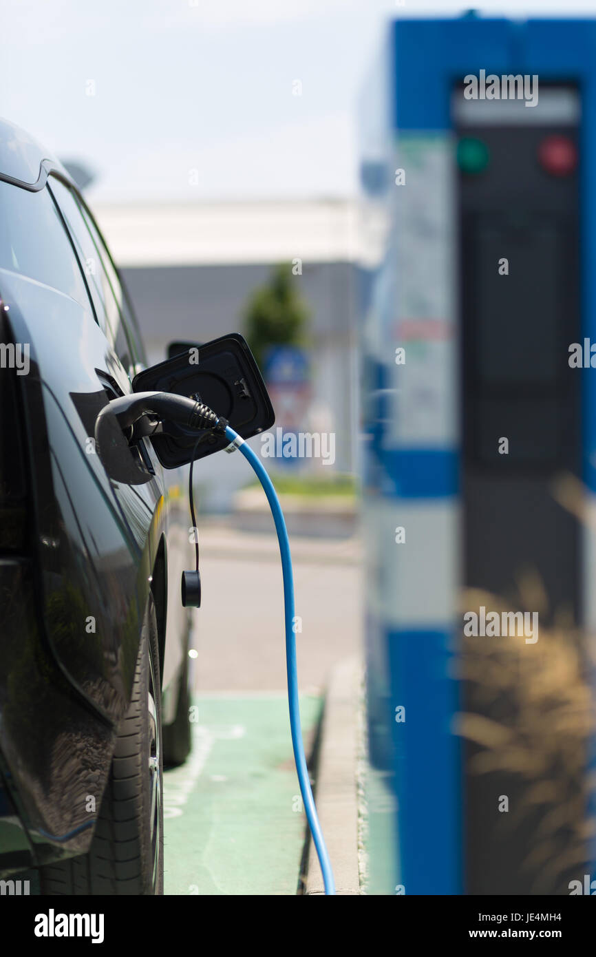 Alimentation pour voiture électrique de la charge. Station de recharge pour voitures électriques. Close up du bloc d'alimentation branché sur une voiture électrique en cours de charge. Banque D'Images