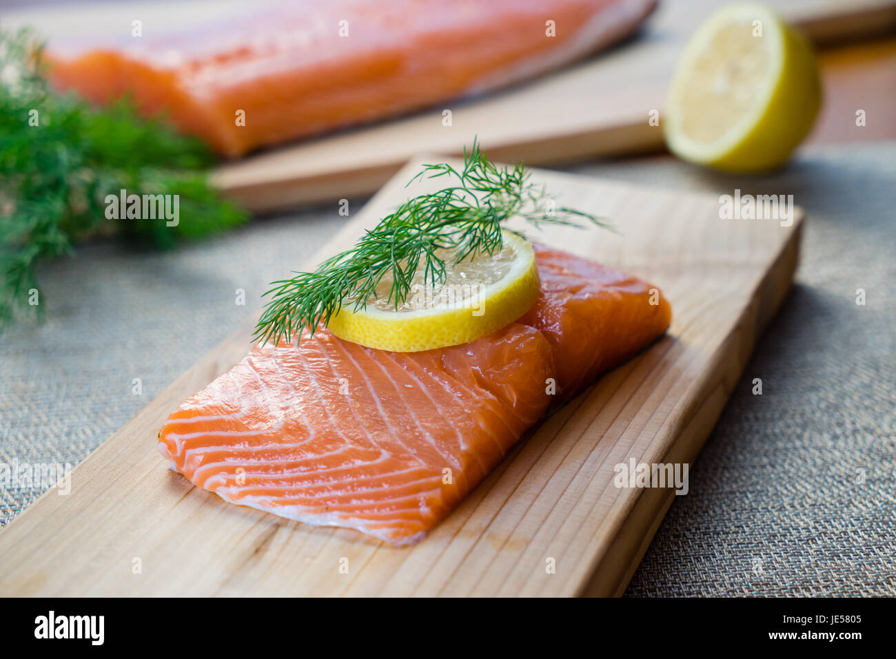 Le saumon frais sur planche de cèdre à l'aneth et citron. Banque D'Images