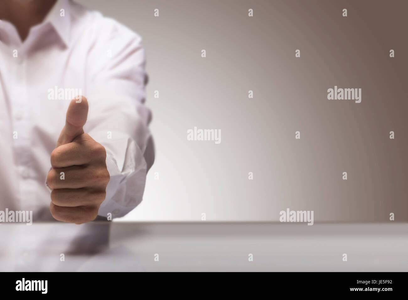 Homme avec un pouce vers le haut à l'arrière-plan d'un tableau brillant et exemplaire de l'espace sur le droit, pour l'illustration de l'image concept de service d'excellente qualité. Banque D'Images