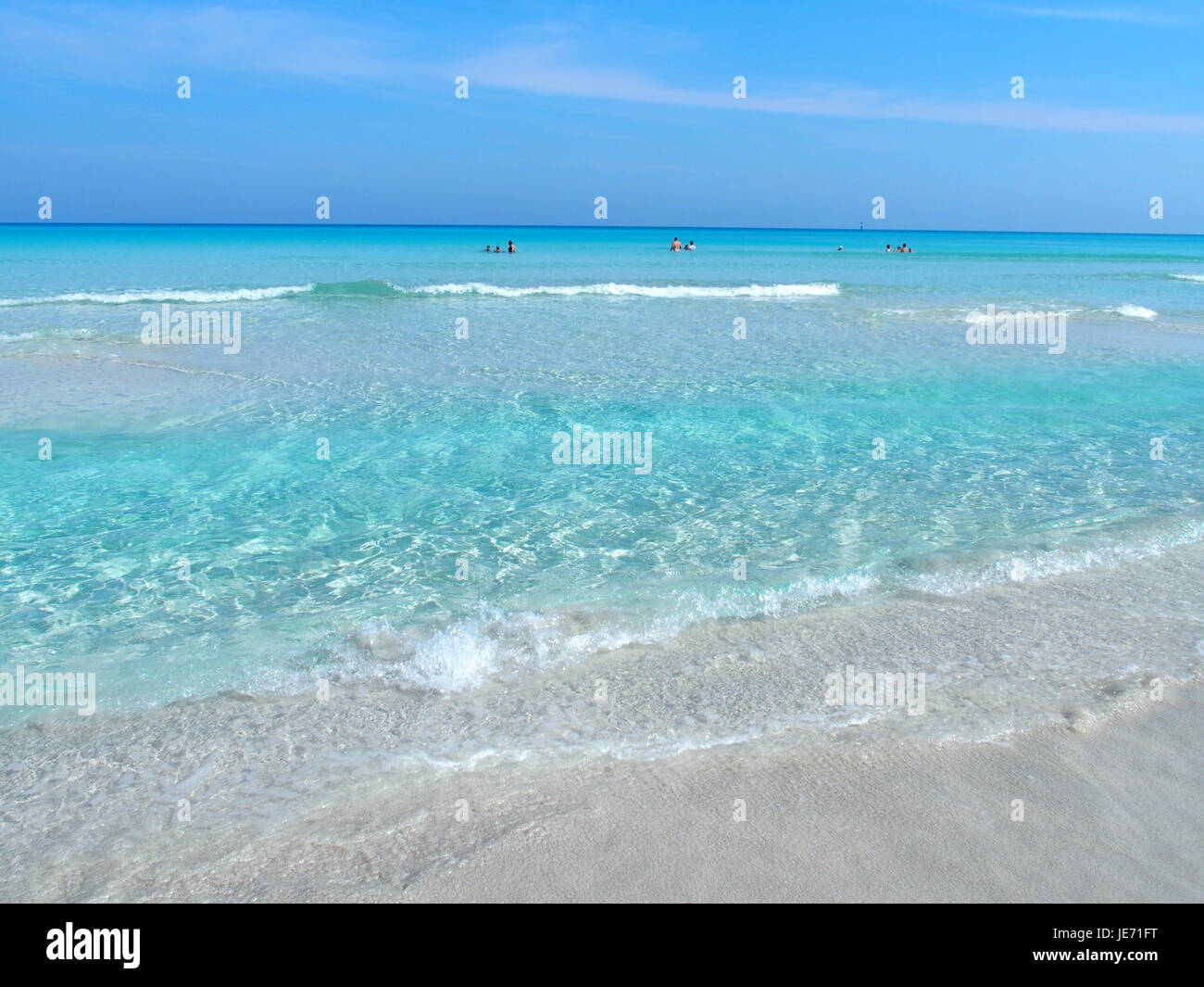 Plage de sable à la mer des Caraïbes dans la ville de Varadero à Cuba à l'eau claire sur le paysage de mer et de palmiers exotiques et d'arbres, ciel bleu clair en 2017. Banque D'Images