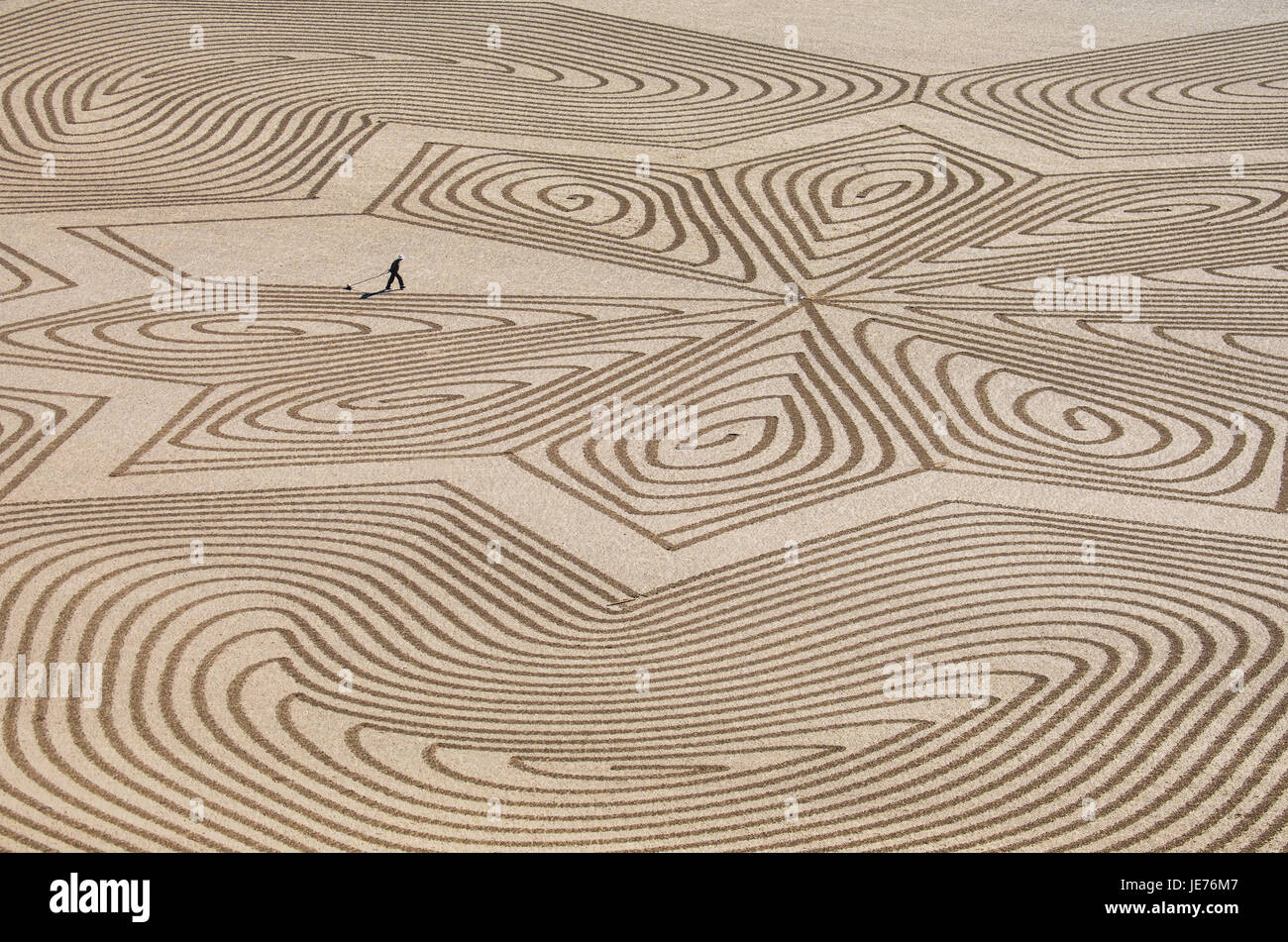 L'artiste Simon sable Beck de finir un immense motif géométrique dans le sable à marée basse à Brean plage dans le Somerset UK Banque D'Images