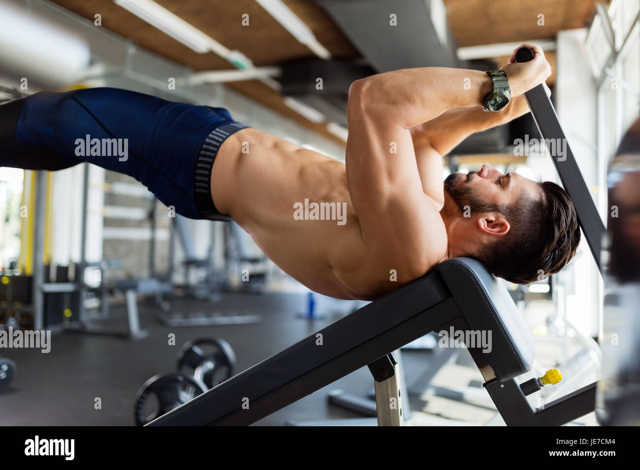 Les jeunes bel homme faire de l'exercice pour les abdominaux Banque D'Images