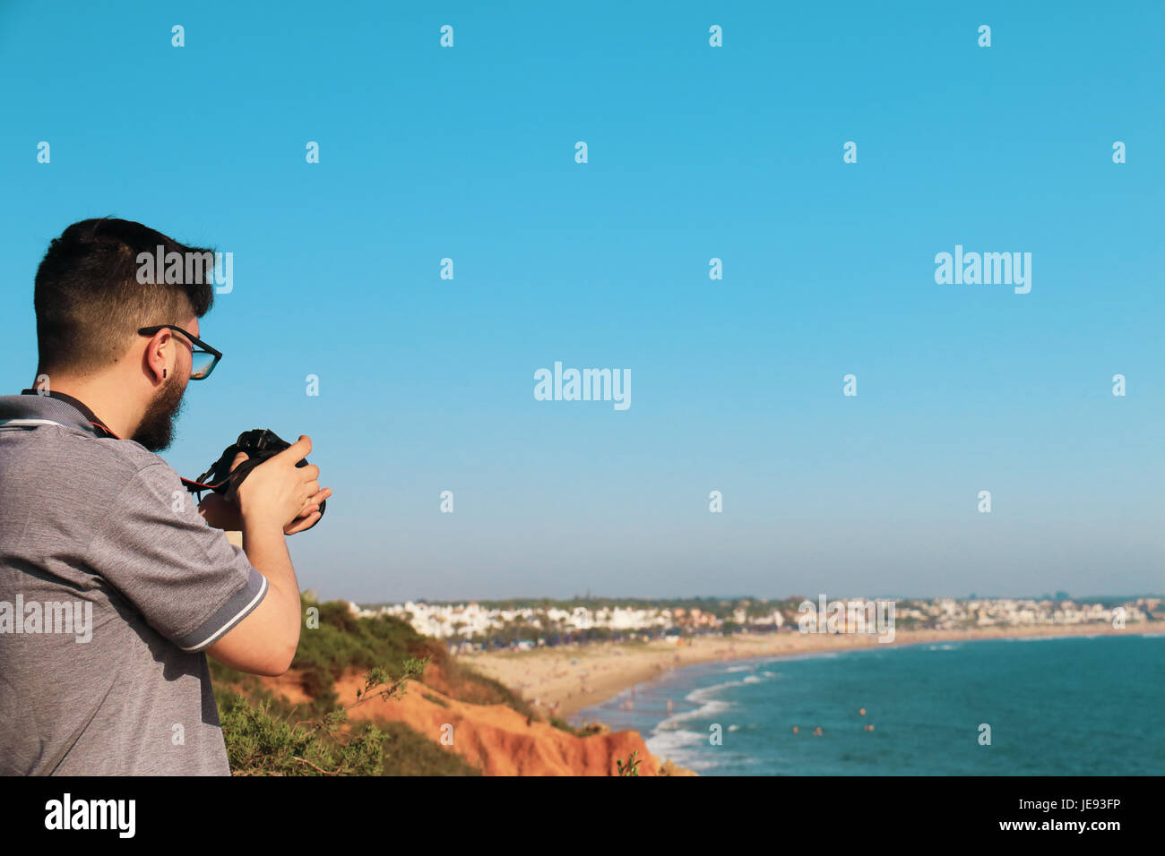 Le jeune photographe de faire des photos d'un paysage marin avec son appareil photo Banque D'Images