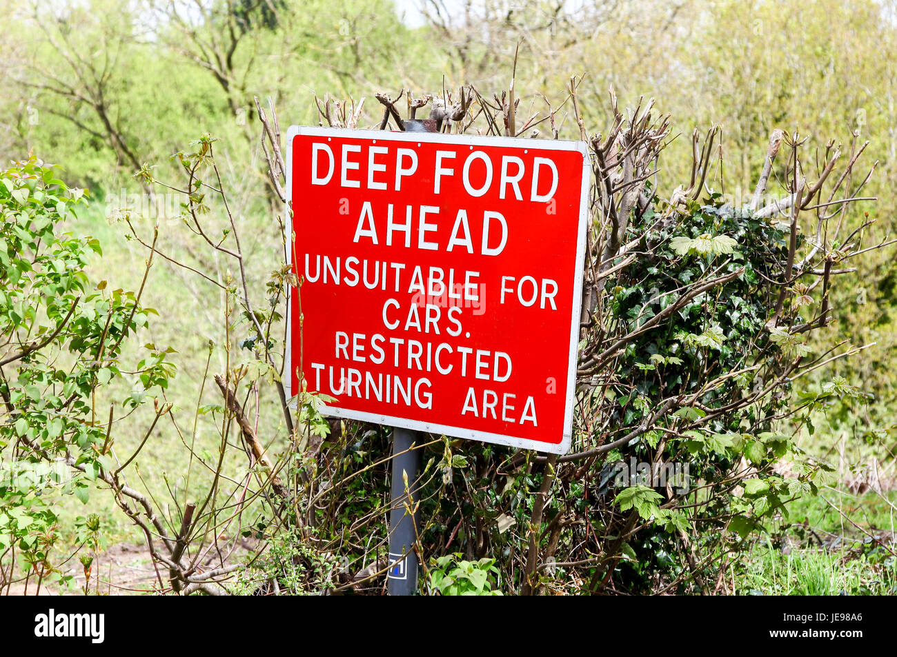 Un panneau d'avertissement rouge disant "Deep Ford à venir ne convient pas aux voitures braquage restreint" Banque D'Images Un panneau d'avertissement rouge disant "Deep Ford à venir ne convient pas aux voitures braquage restreint" Banque D'Images