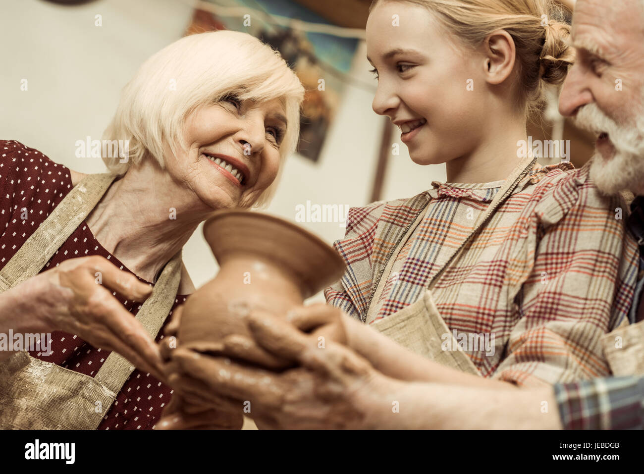 Grand-mère et grand-père avec sa petite-fille d'argile atelier vase de holding Banque D'Images