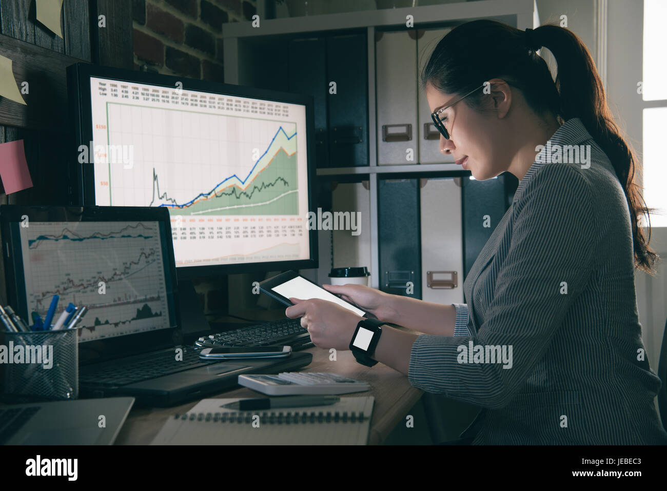 Sweet femme avenante vide regarder tablet computer in office. mixed race chinoise asiatique model holding pad et se concentrer sur l'écran. Banque D'Images