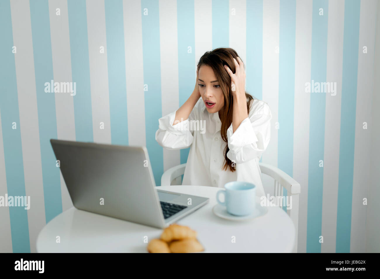 Belle jeune femme inquiète while using laptop Banque D'Images