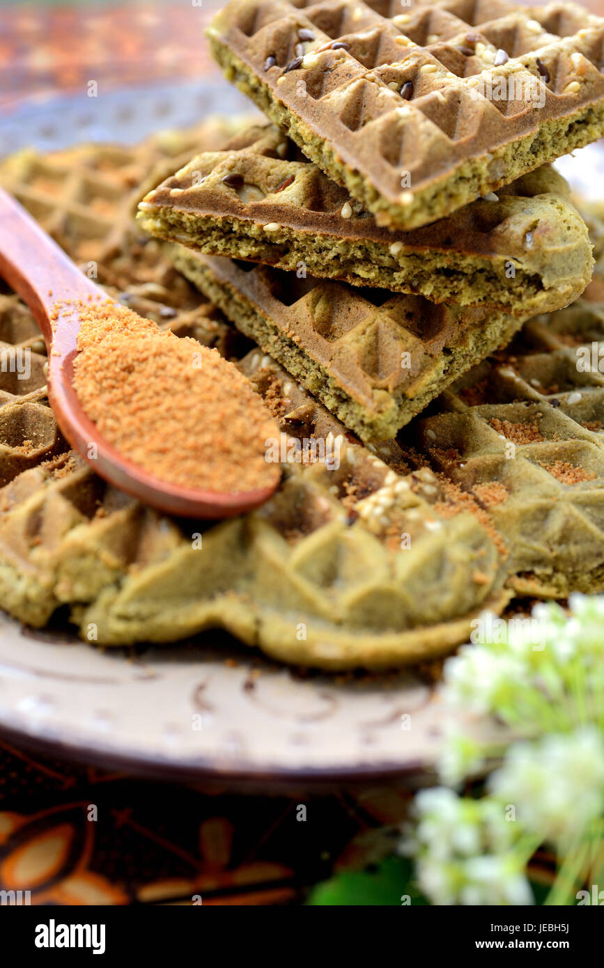 Gaufres maison avec plus de matcha, pistaches, graines de lin. Décorées avec du sucre de coco. Banque D'Images