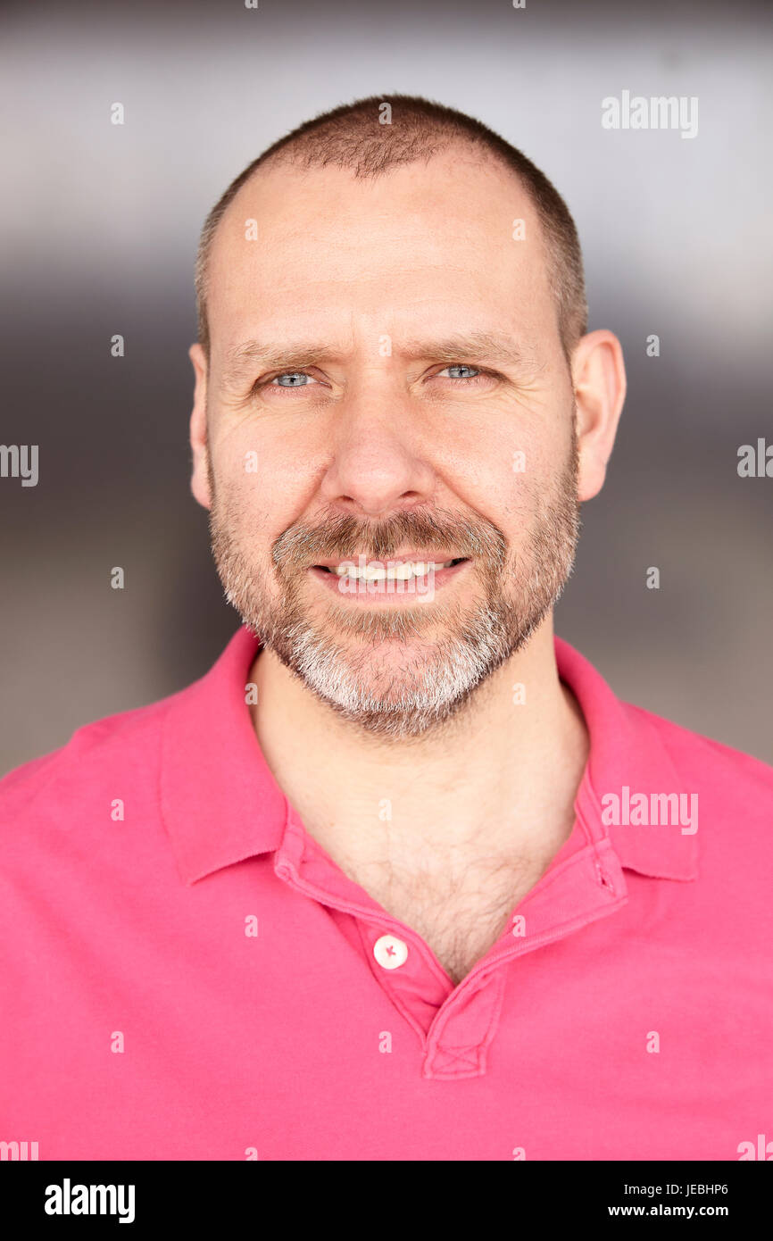 Portrait of happy casual man en t-shirt rose. Banque D'Images