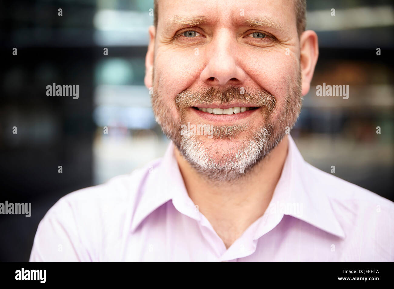 Portrait of smiling businessman standing en face de son bureau. Banque D'Images