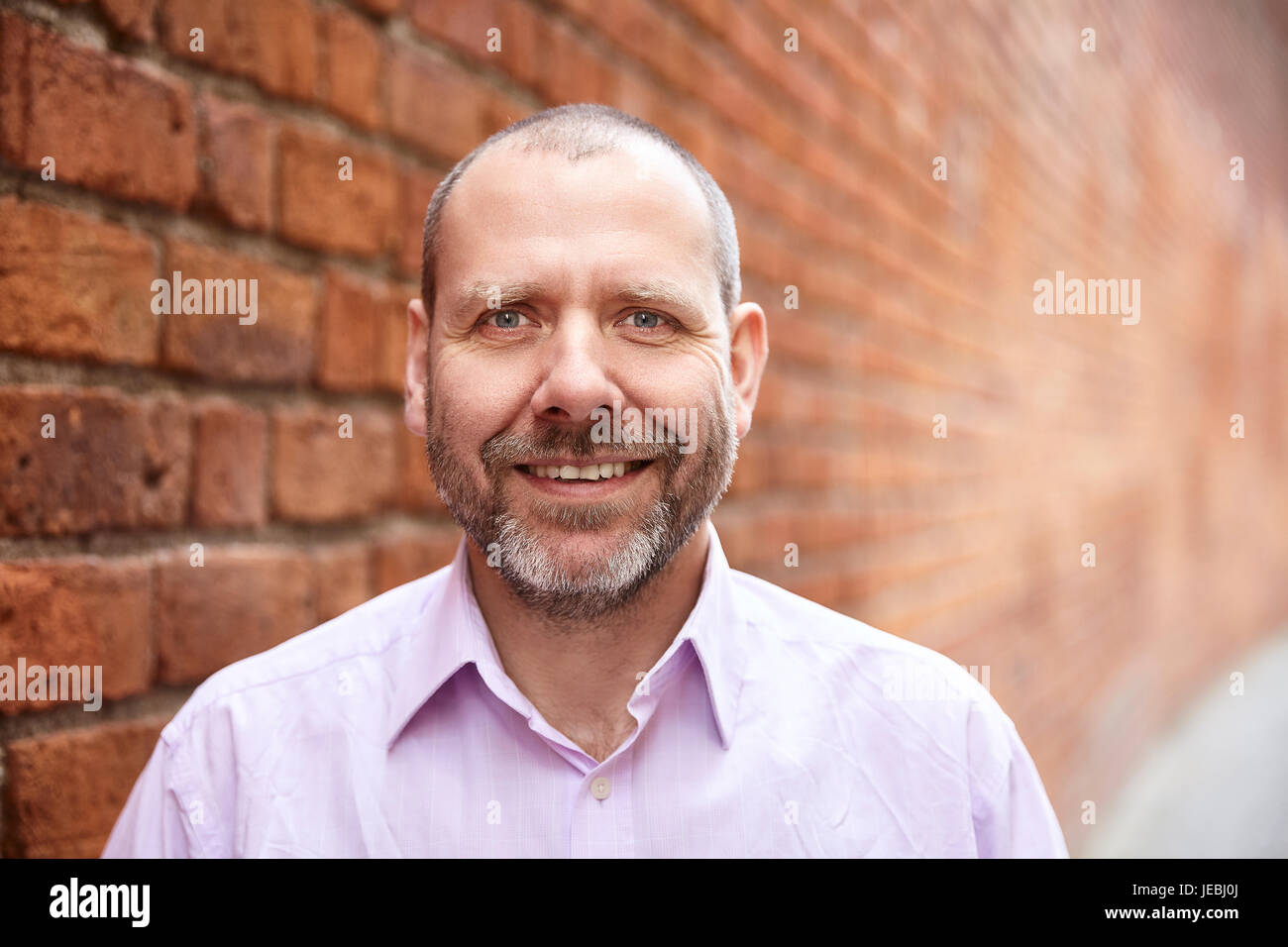 Portrait of smiling man contre un mur arrière-plan. Banque D'Images