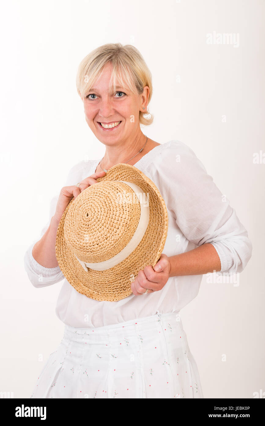 Portrait d'un milieu blond attrayant de european woman wearing white dress showin hat holding happy face - moitié du corps - studio shot sur w Banque D'Images