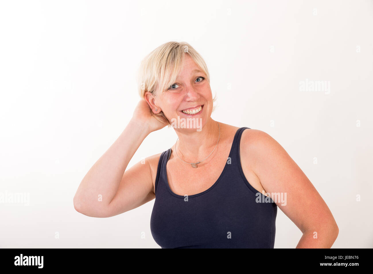 Portrait d'une chevelure de blonde attrayant de mi'woman débardeur bleu showin happy face - moitié du corps - studio shot sur fond blanc. Banque D'Images