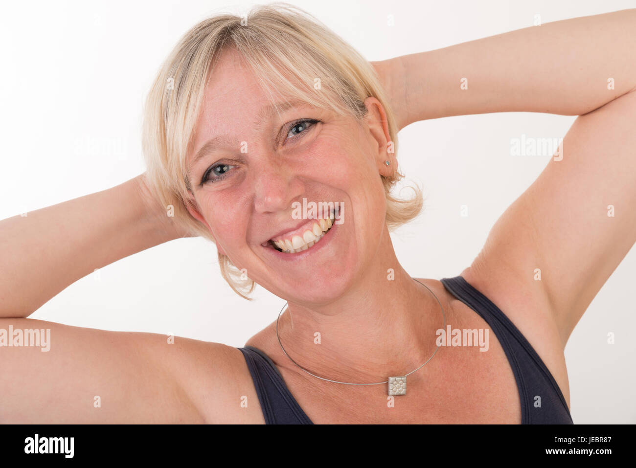 Portrait d'un milieu blond attrayant de femme européenne portant haut bleu montrant heureux face - moitié du corps - studio shot on white background Banque D'Images